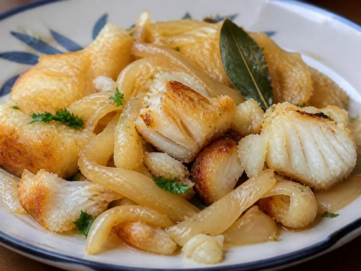 Pormenor de uma porção de Lascas de Bacalhau Frito com Cebolada