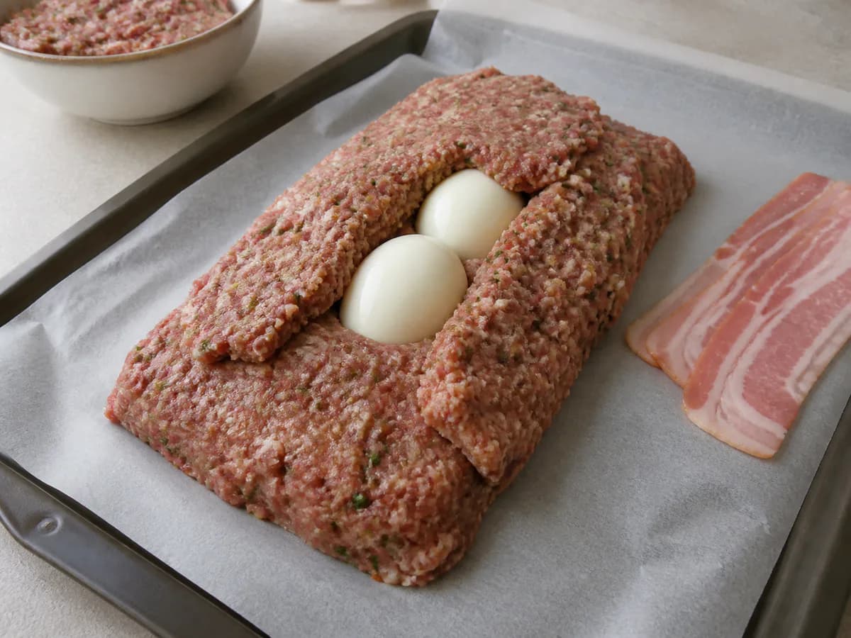 Preparação de Bolo de Carnes com Ovo e Bacon durante a confeção