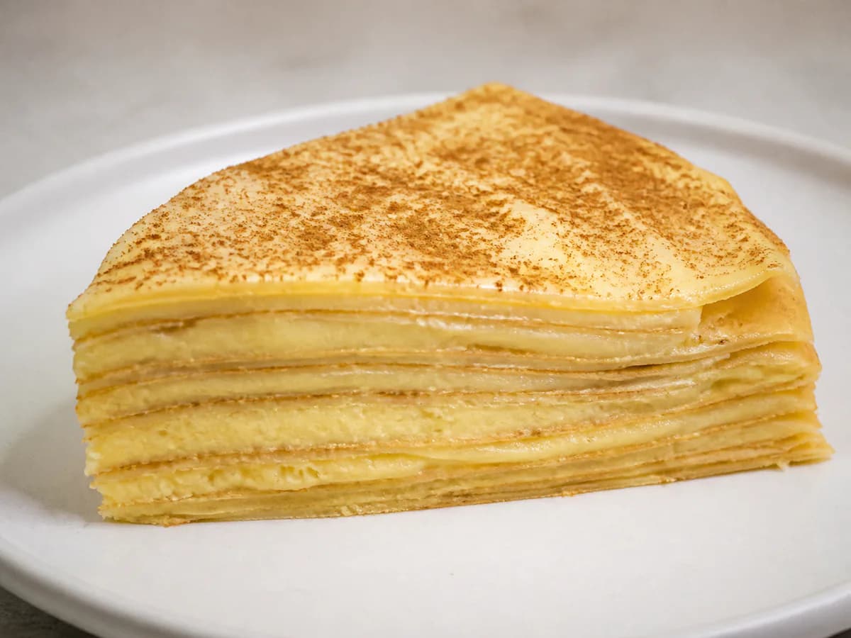 Pormenor de uma porção de Bolo de Crepes com Creme de Ovos e Canela