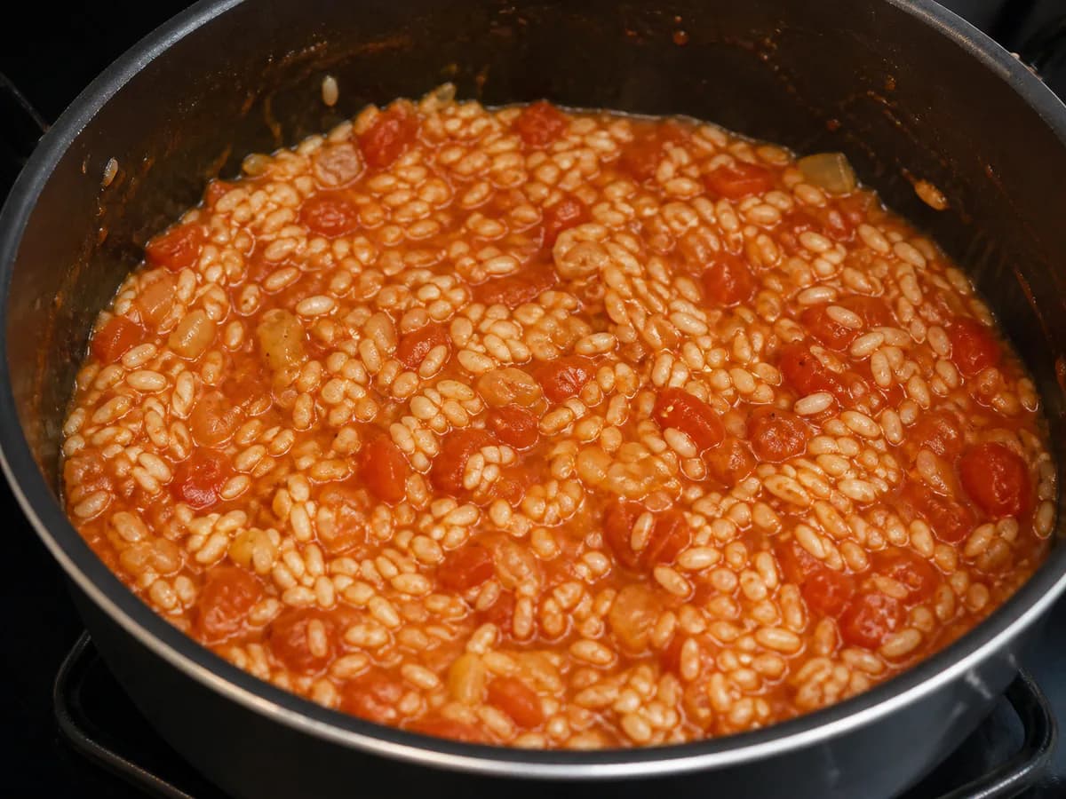 Preparação de Arroz de Tomate com Salsichas durante a confeção