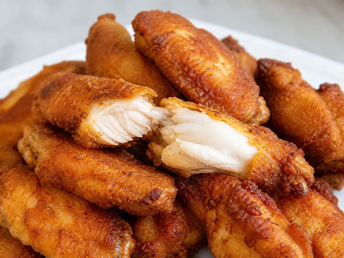 Pormenor de uma porção de Asinhas de Galinha Empanadas e Fritas