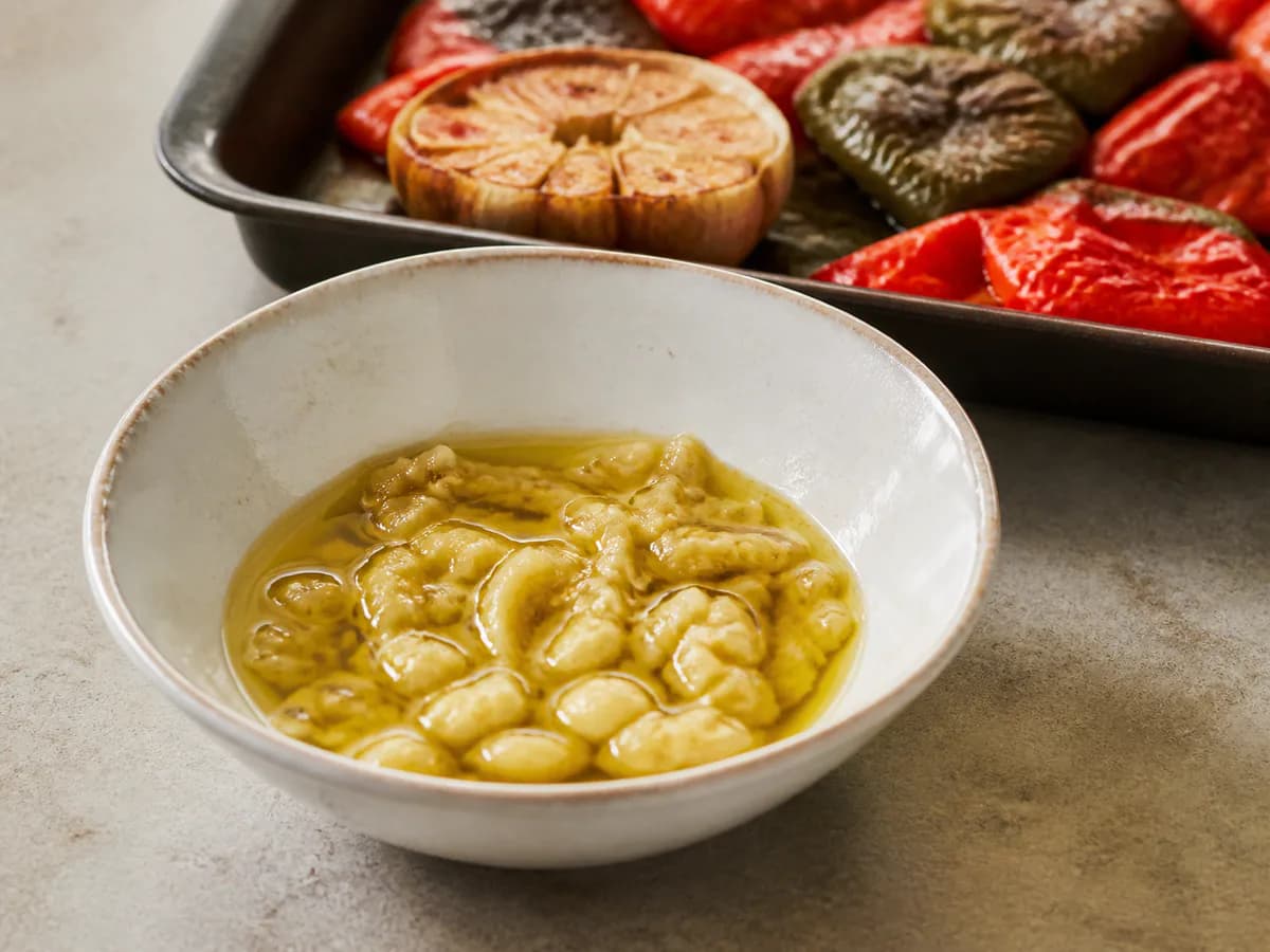 Preparação de Bacalhau Assado na Brasa com Batatas a Murro e Pimentos durante a confeção