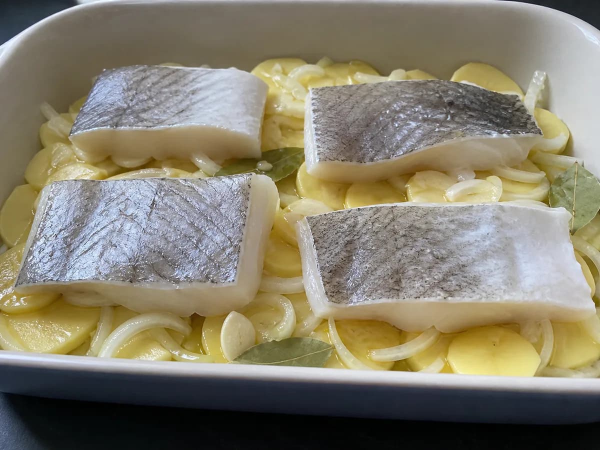 Preparação de Bacalhau Assado no Forno com Batatas e Broa durante a confeção