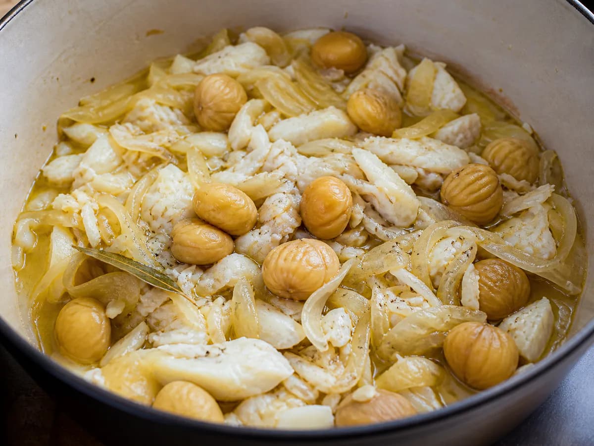 Preparação de Bacalhau à Cebolada com Castanhas durante a confeção