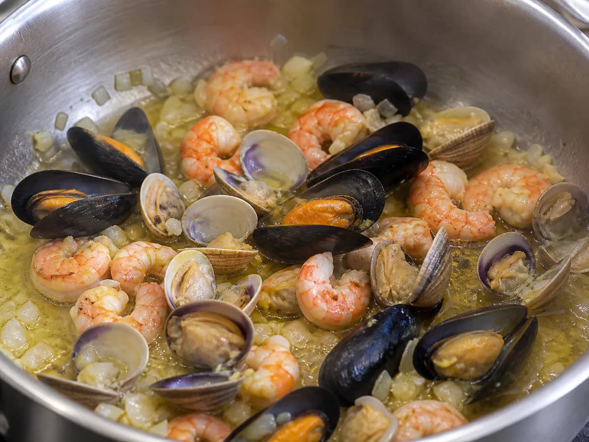 Preparação de Bacalhau Frito com Molho de Frutos do Mar durante a confeção