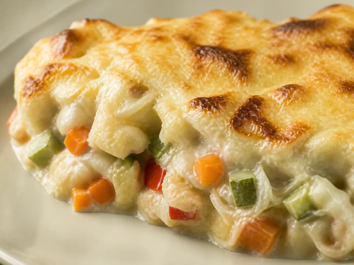 Pormenor de uma porção de Bacalhau Gratinado com Legumes