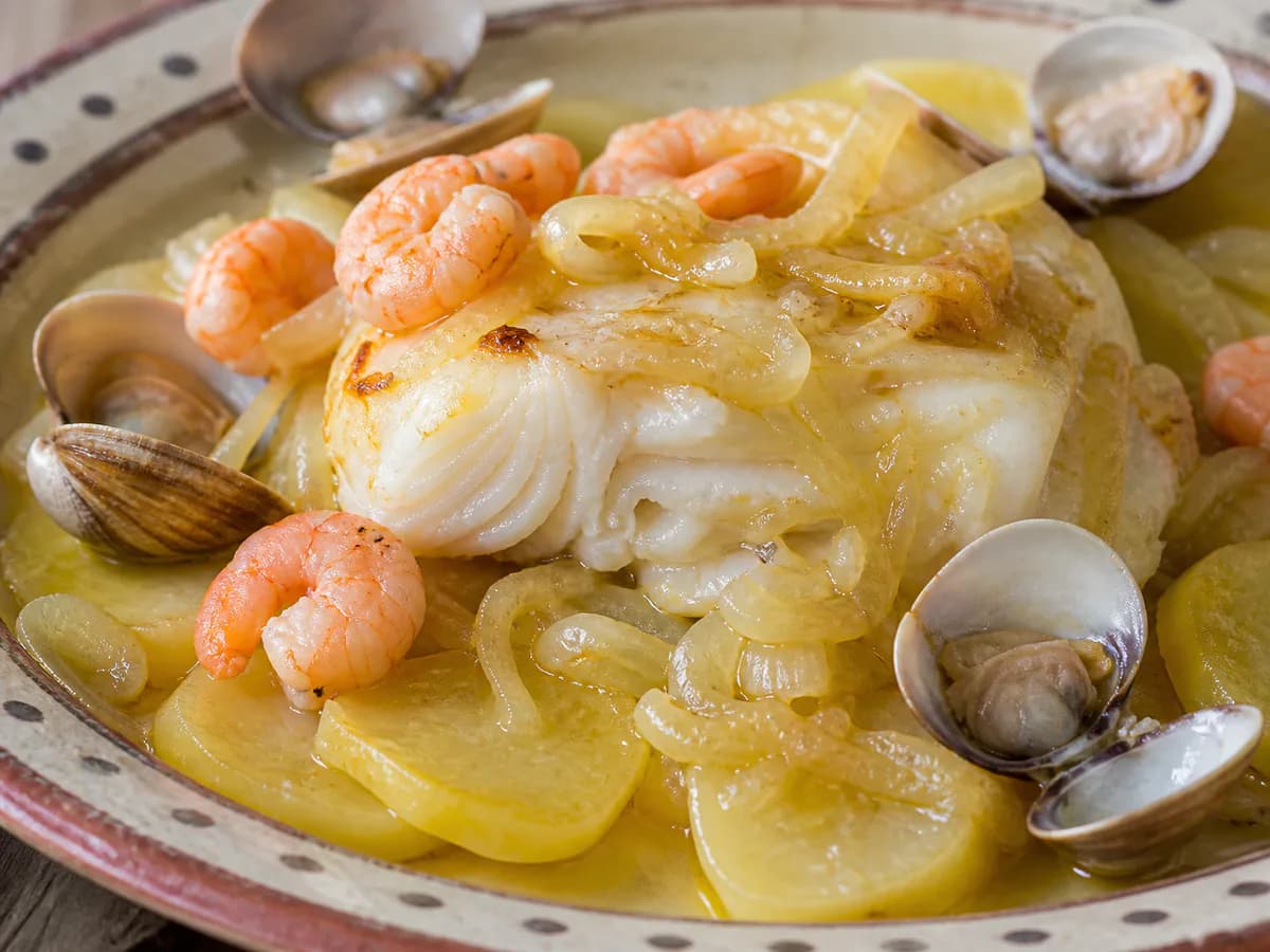 Pormenor de uma porção de Bacalhau no Forno com Batatas, Camarão e Ameijoas