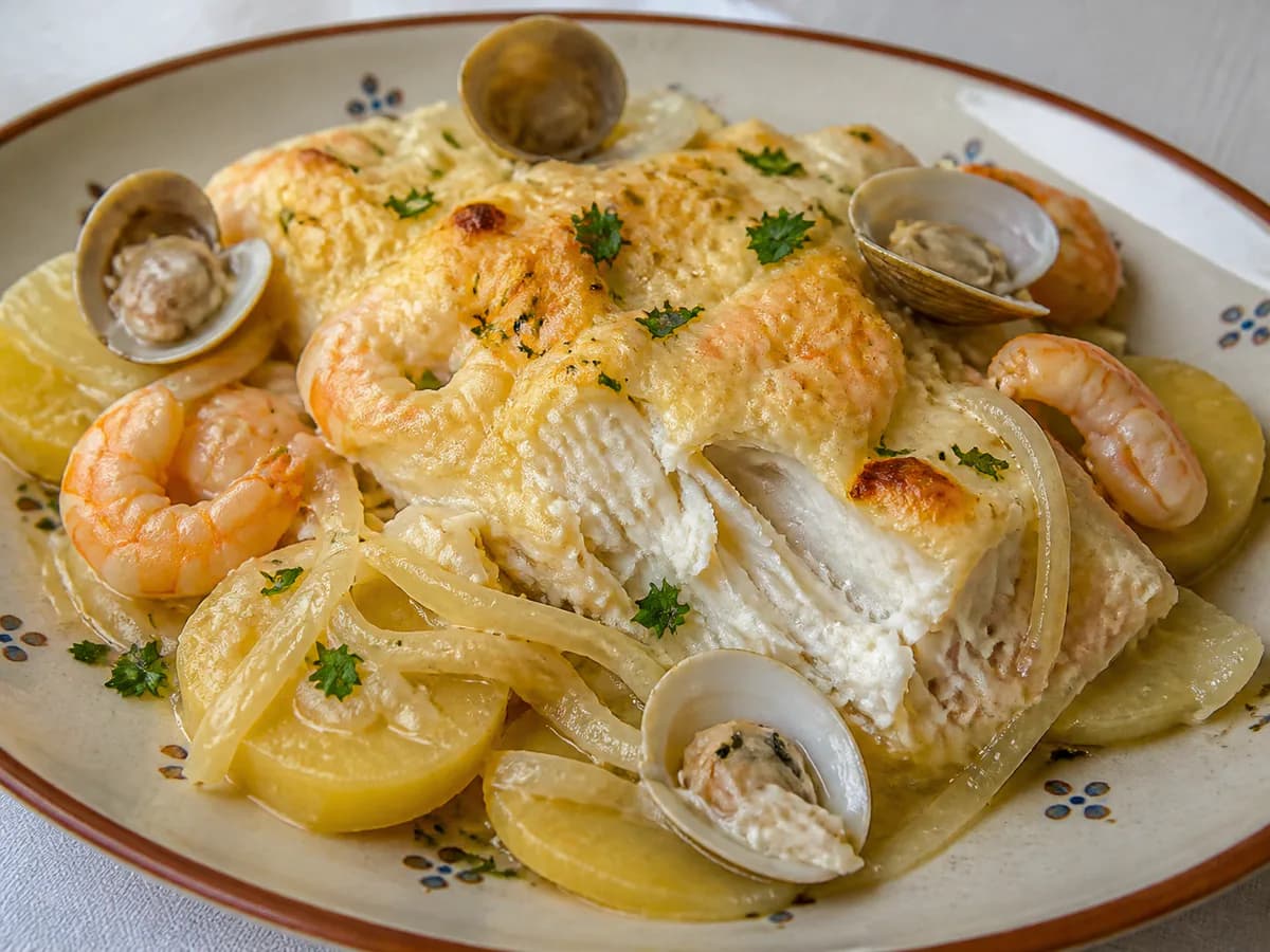Pormenor de uma porção de Bacalhau no Forno com Batata, Camarão e Ameijoas