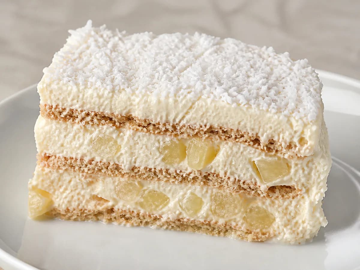 Pormenor de uma porção de Bolo de Bolacha Muito Cremoso com Ananás e Coco