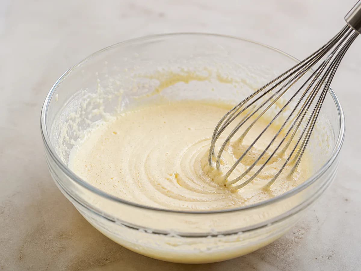 Preparação de Bolo de Fécula de Batata com Cobertura de Leite Creme durante a confeção
