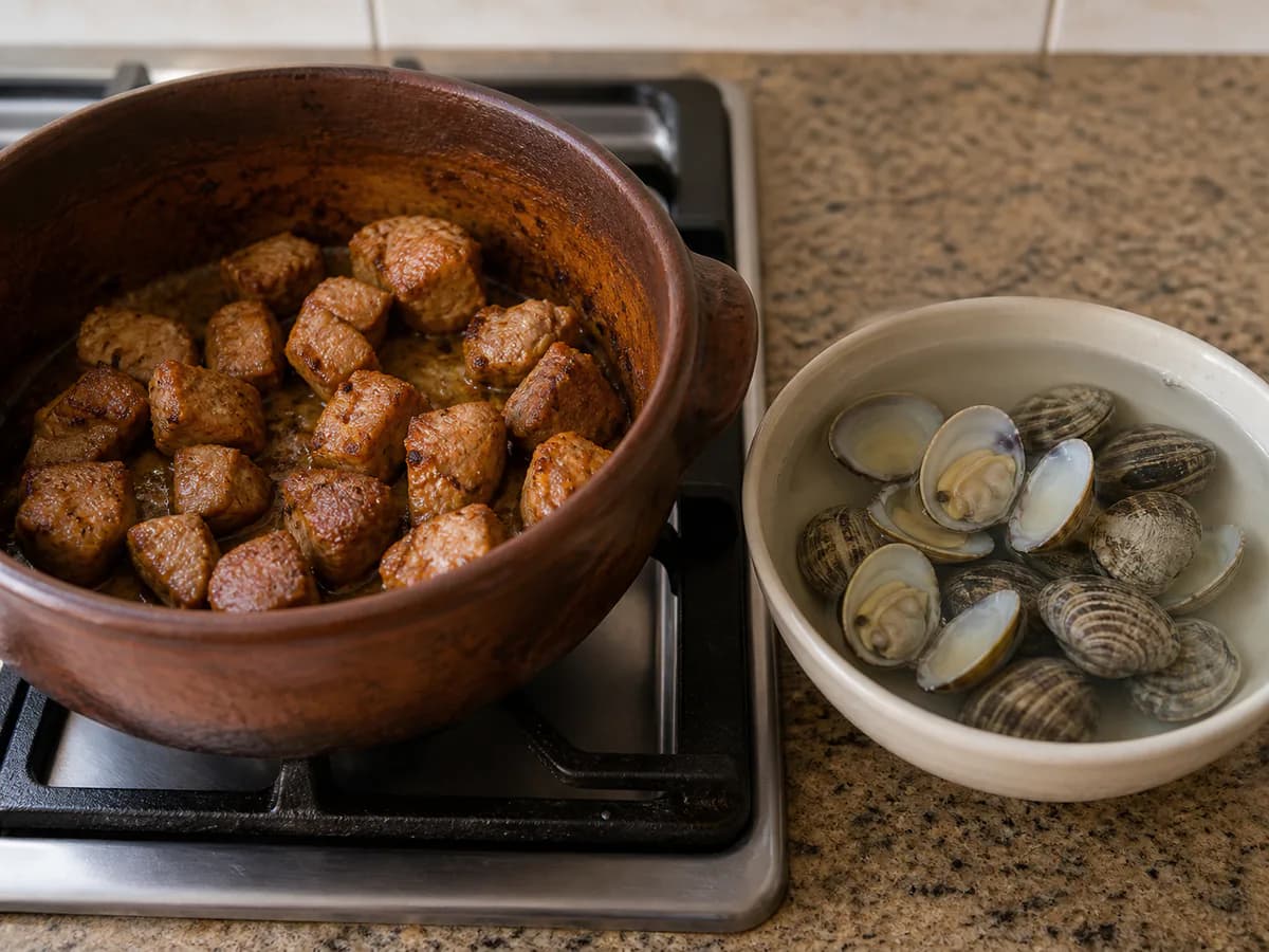 Preparação de Carne de Porco à Alentejana com Cominhos durante a confeção