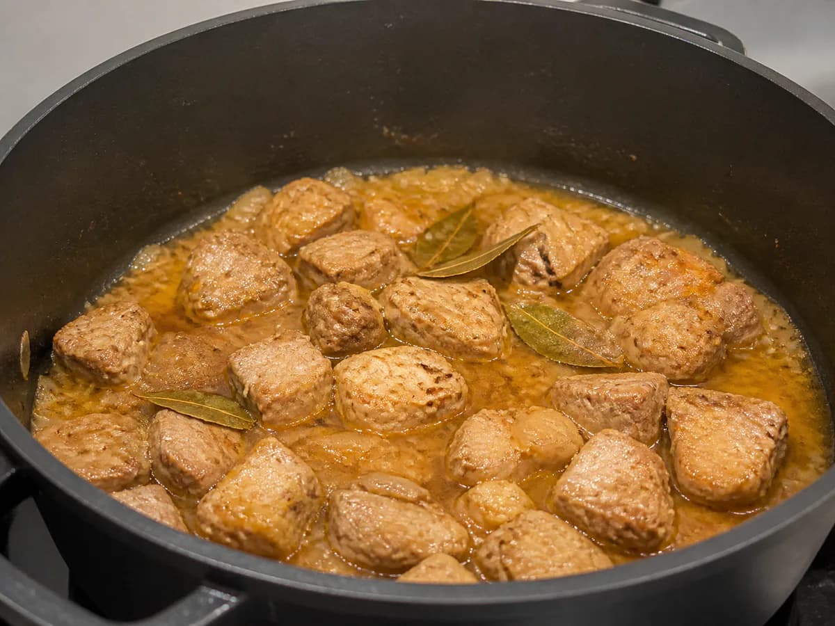 Preparação de Carne de Porco à Alentejana com Batatas durante a confeção