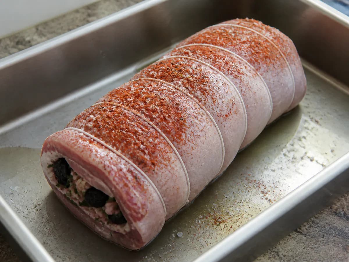 Preparação de Carne de Porco Recheada com Ameixas e Bacon durante a confeção