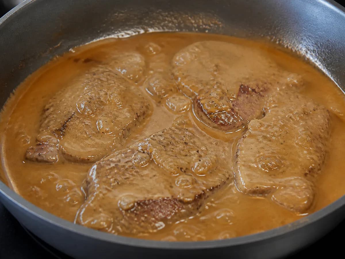 Preparação de Bife com Ovo a Cavalo em Molho de Café durante a confeção