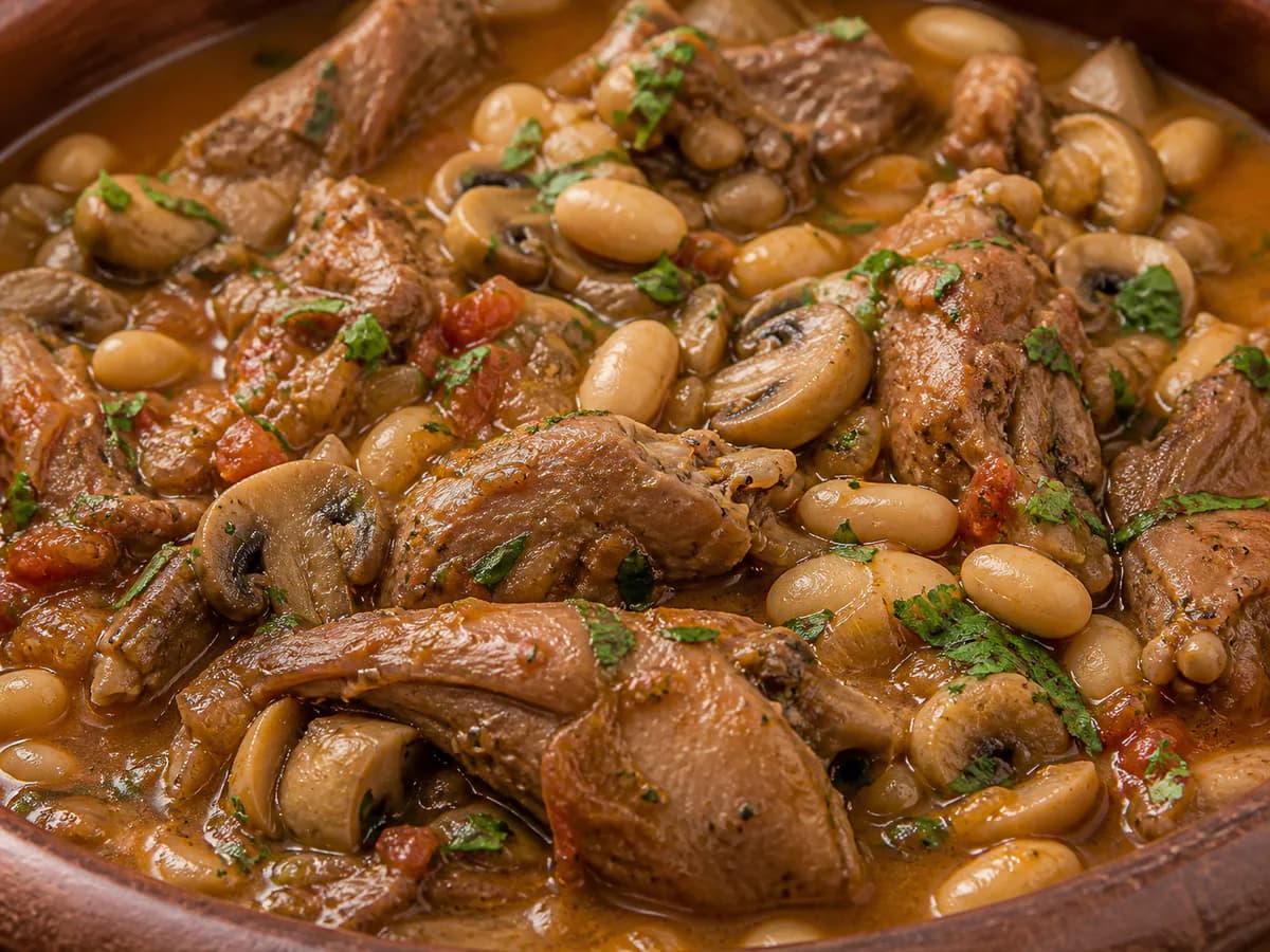 Pormenor de uma porção de Coelho Guisado com Feijão Branco e Cogumelos