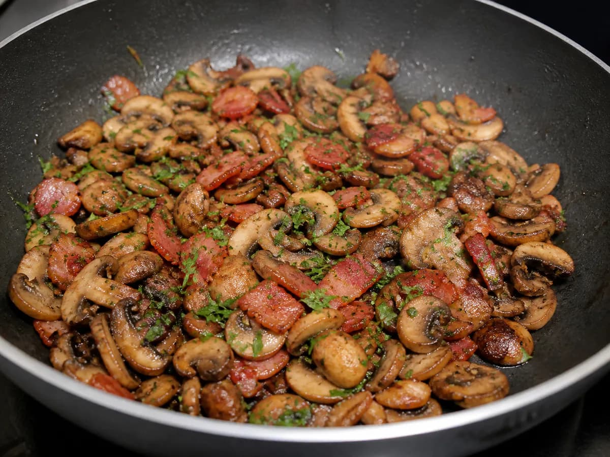 Preparação de Cogumelos Salteados com Bacon, Coentros e Queijo durante a confeção