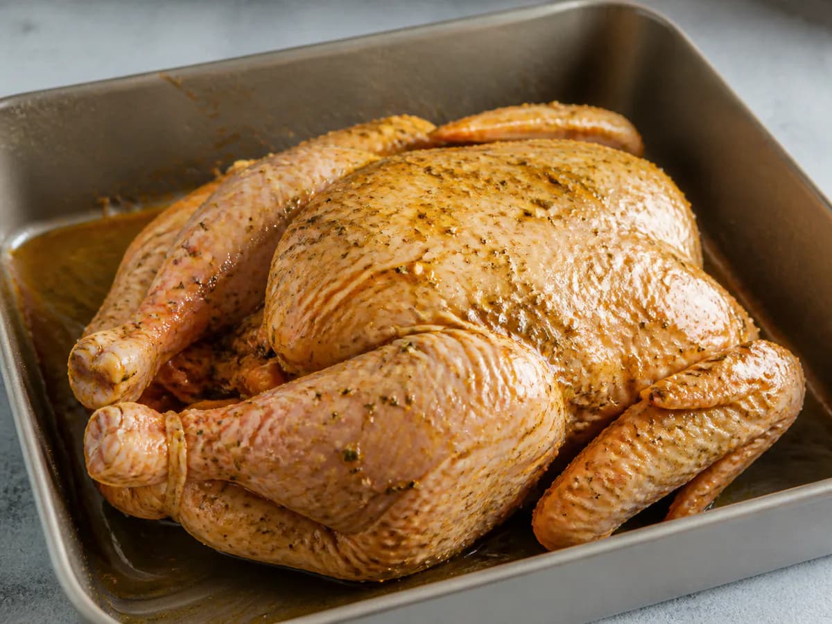 Preparação de Frango Assado com Cominhos, Orégãos e Louro durante a confeção