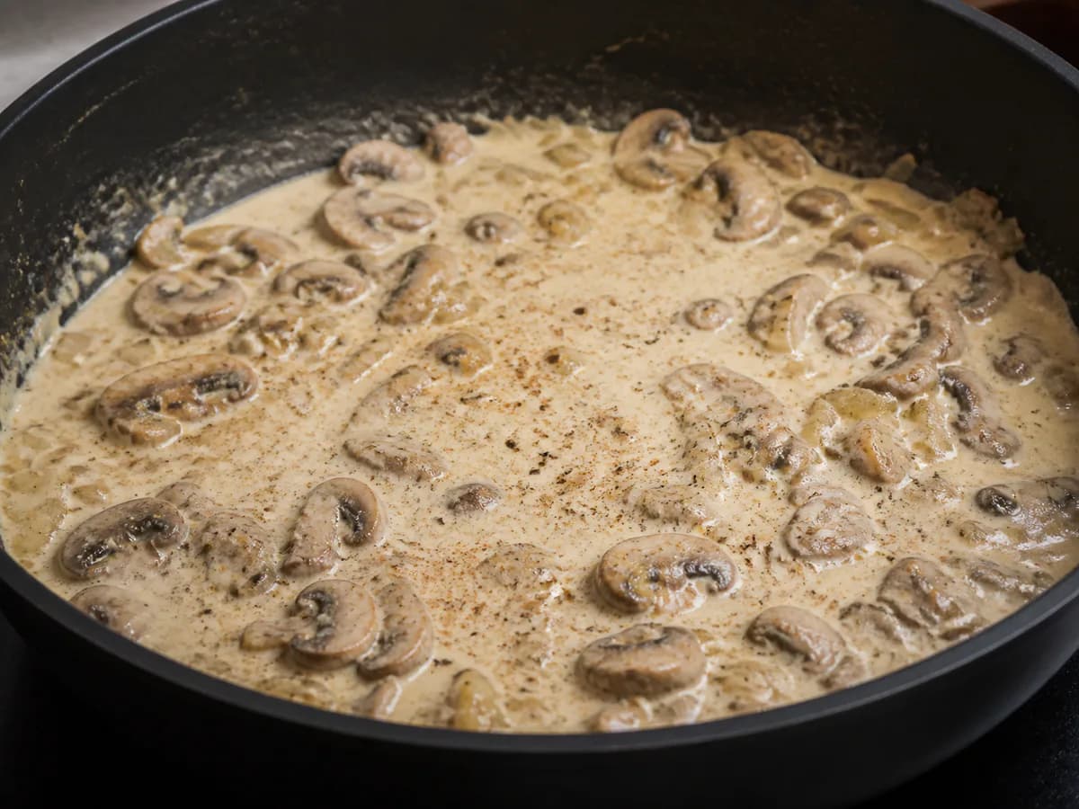 Preparação de Frango Gratinado com Cogumelos durante a confeção