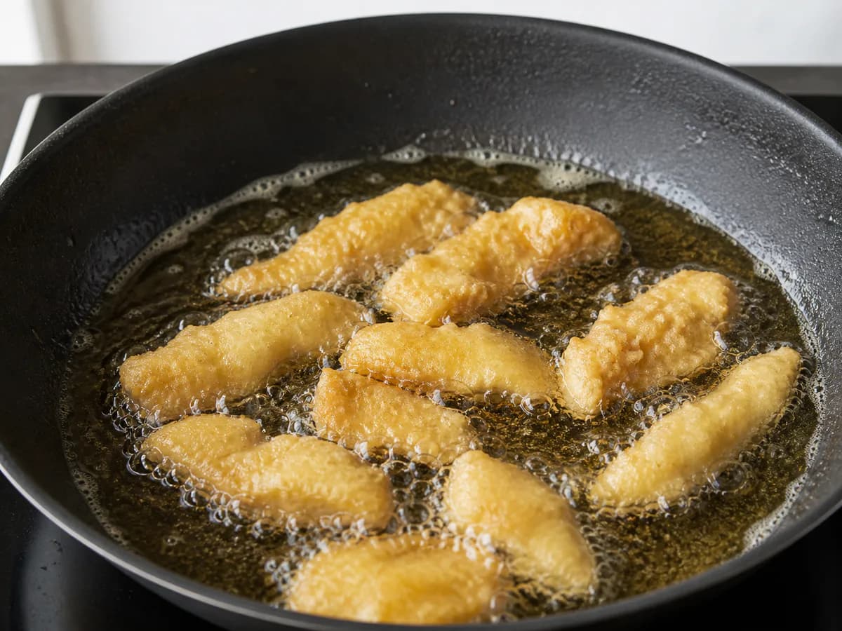 Preparação de Iscas de Bacalhau Fritas com Cebolada durante a confeção