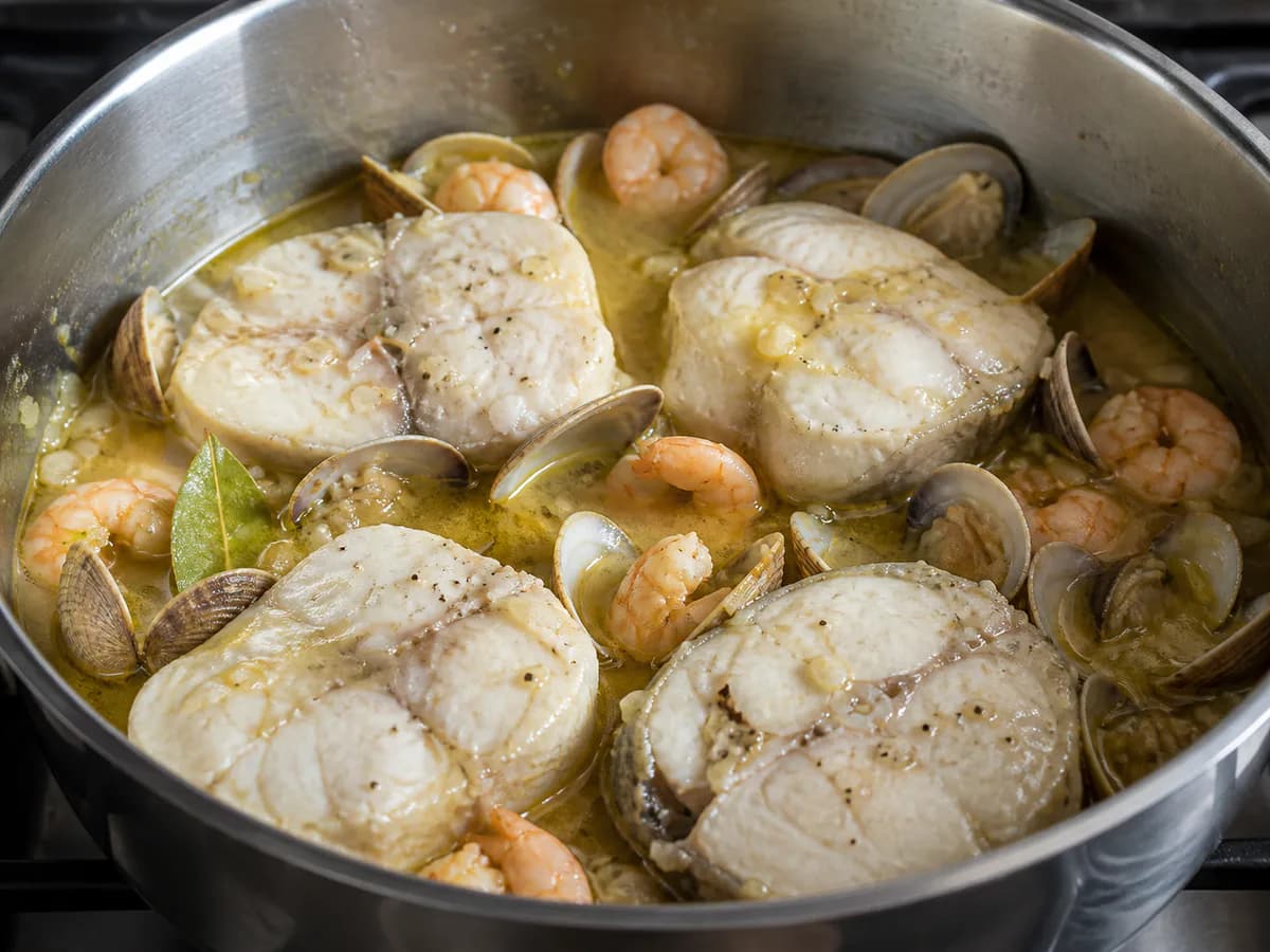 Preparação de Medalhões de Pescada com Ameijoa e Camarão à Marinheira durante a confeção