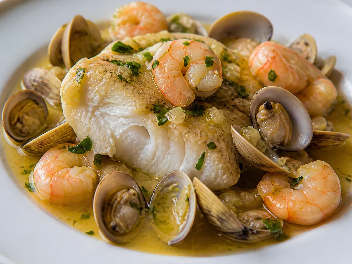 Pormenor de uma porção de Medalhões de Pescada com Ameijoa e Camarão à Marinheira
