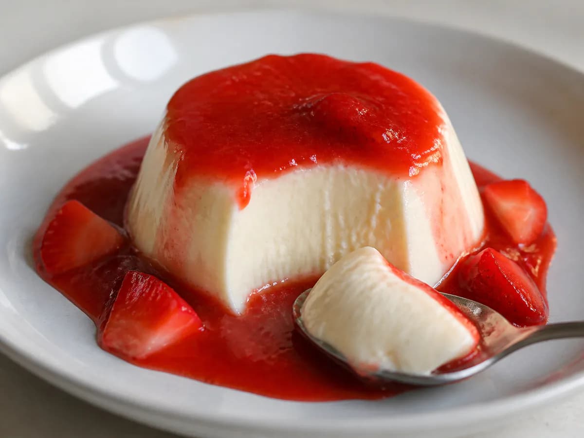 Pormenor de uma porção de Panna Cotta de Baunilha com Coulis de Morango