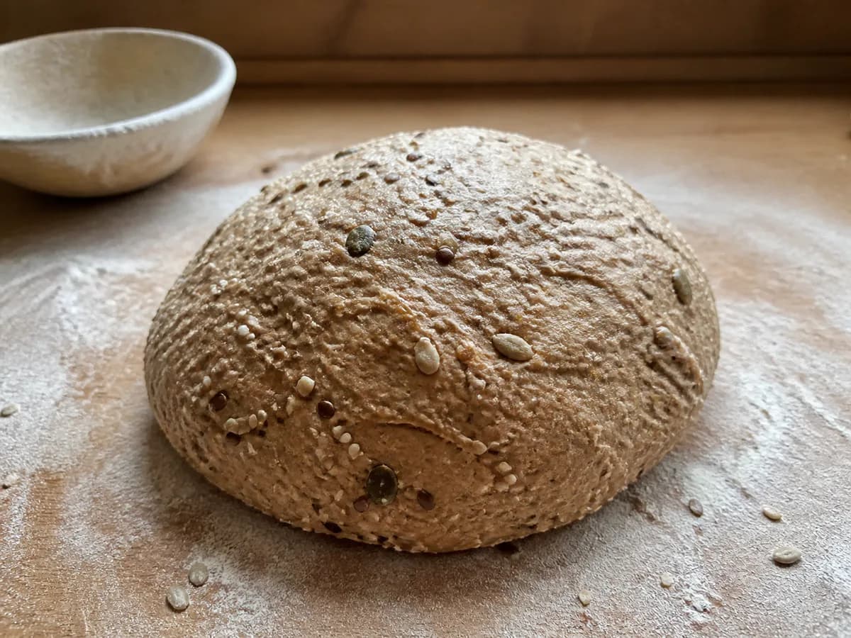 Preparação de Pão Caseiro com Farinha Integral e Sementes durante a confeção