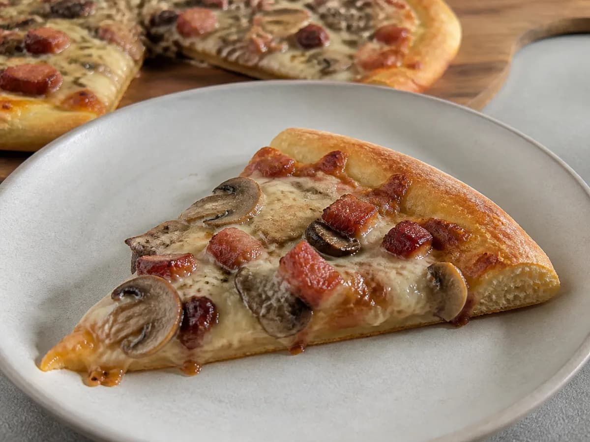 Pormenor de uma porção de Pizza de Bacon e Cogumelos