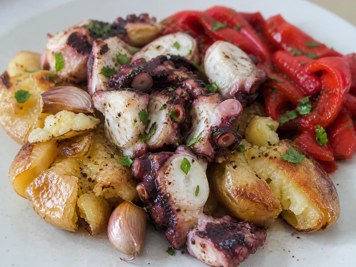 Pormenor de uma porção de Polvo com Batatas a Murro e Salada de Pimentos Vermelhos