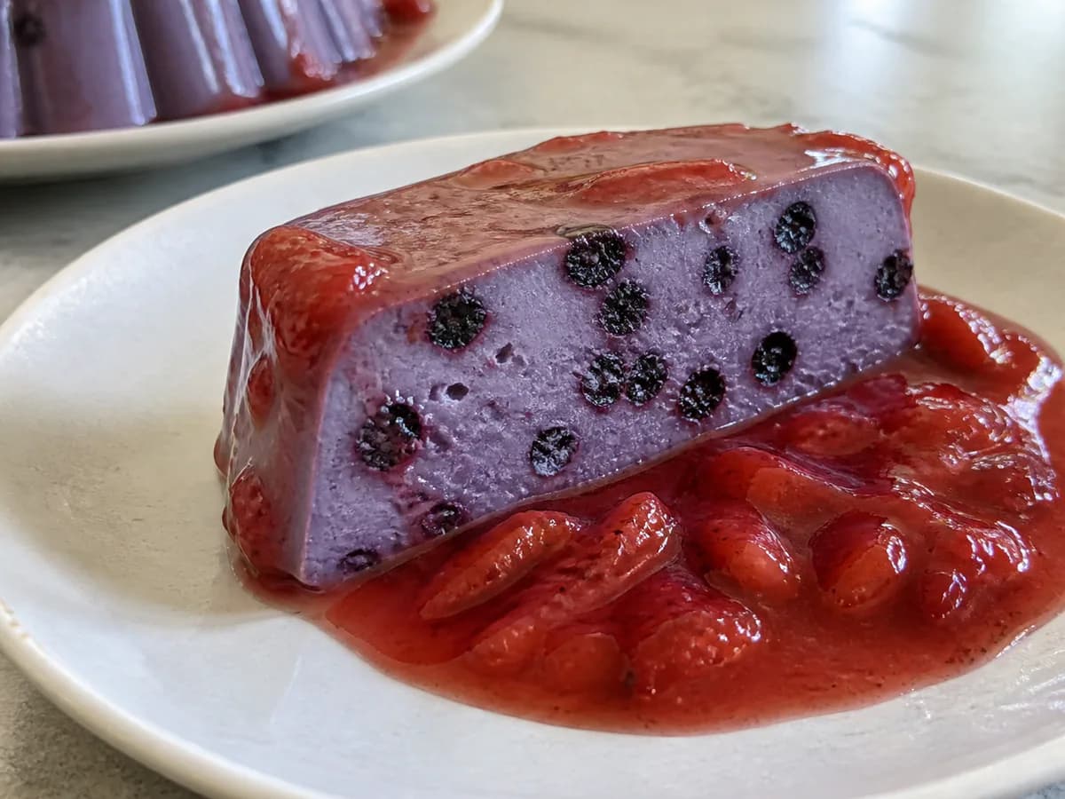 Pormenor de uma porção de Pudim de Mirtilo com Calda de Morango