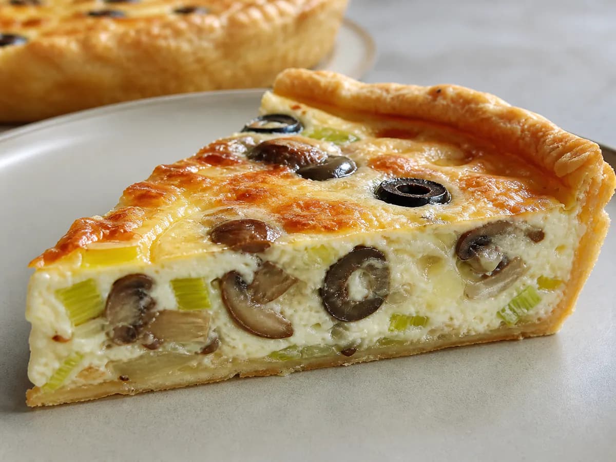 Pormenor de uma porção de Quiche de Alho-Francês com Cogumelos, Queijo e Azeitonas