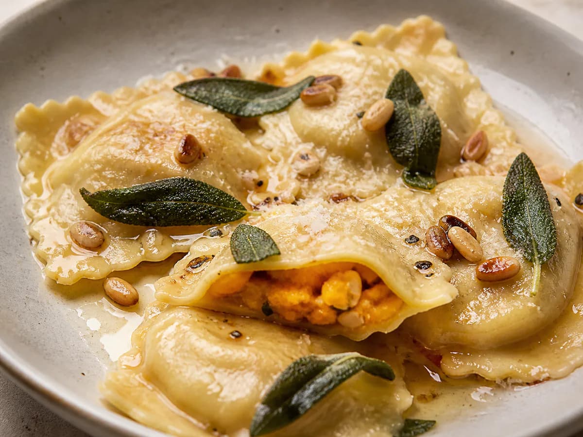 Pormenor de uma porção de Ravioli de Abóbora com Pinhões e Sálvia