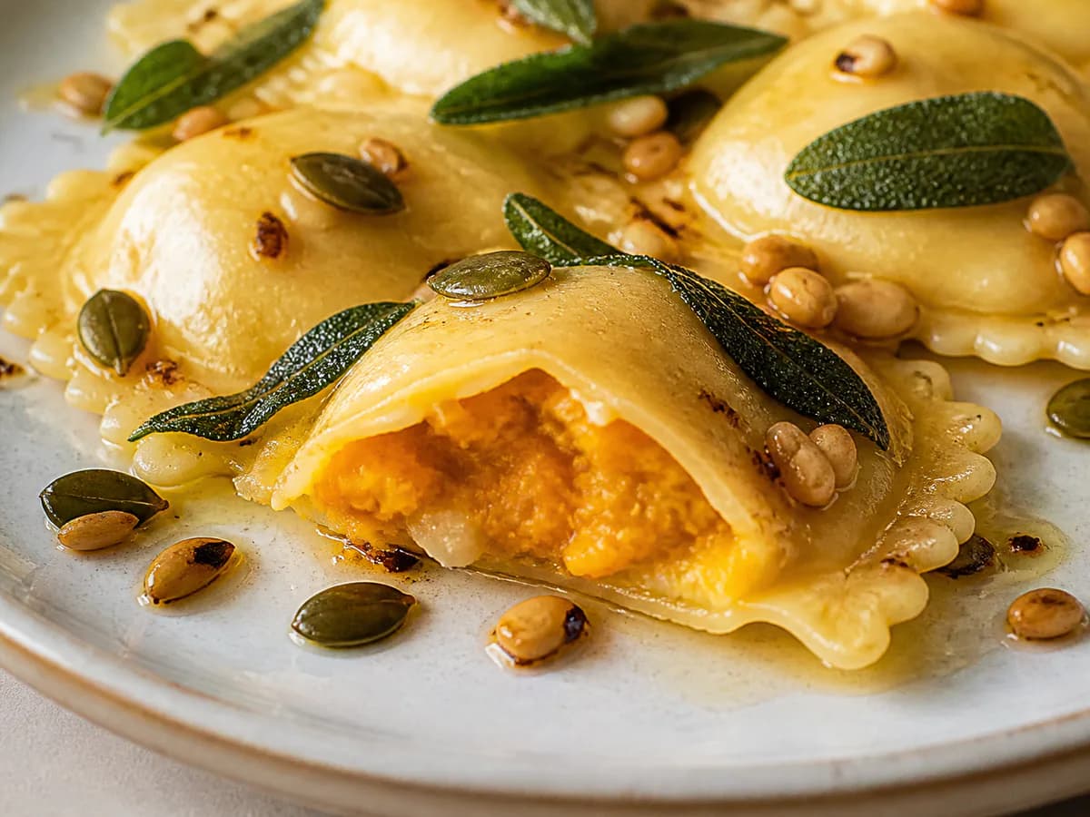 Pormenor de uma porção de Raviolis de Abóbora e Queijo Manchego com Sálvia, Sementes de Abóbora e Pinhões