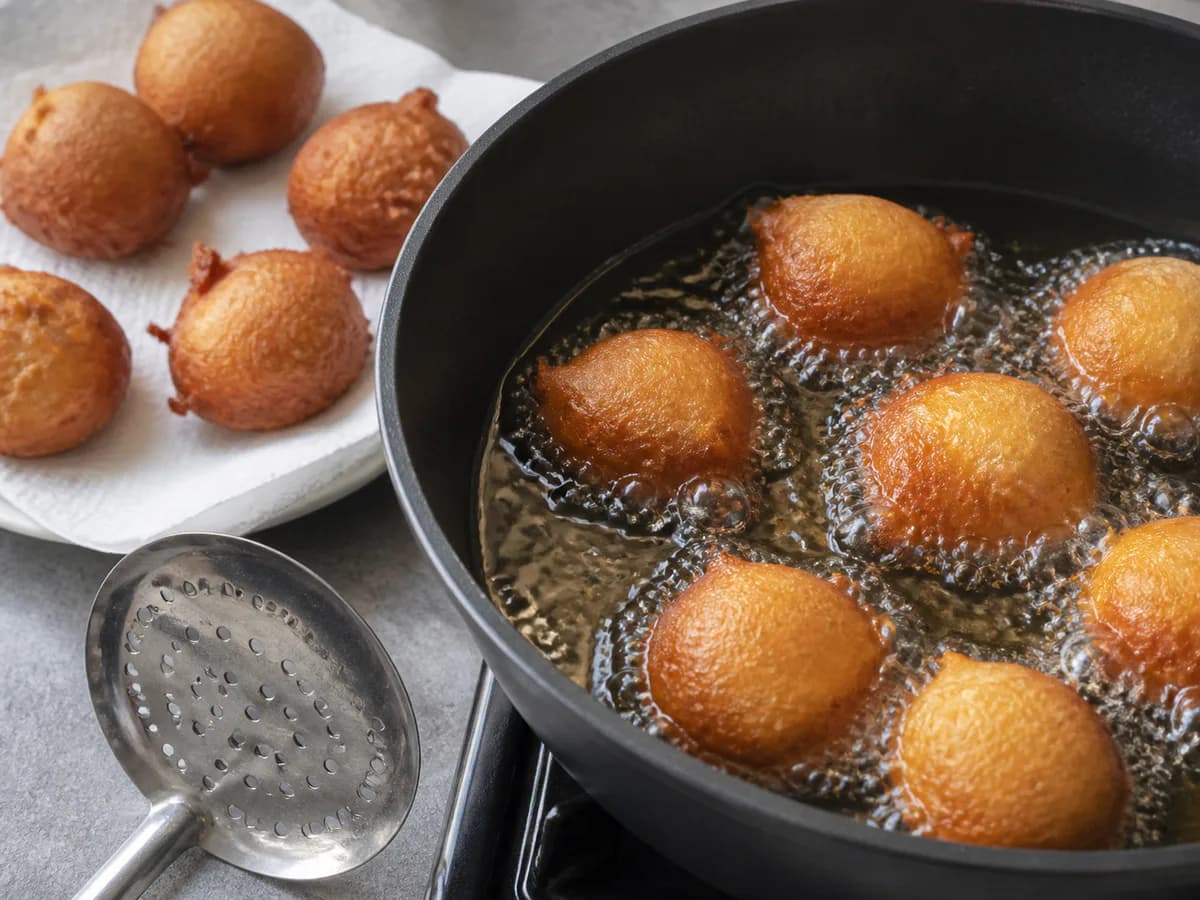 Preparação de Sonhos com Molho Caramelizado de Laranja durante a confeção