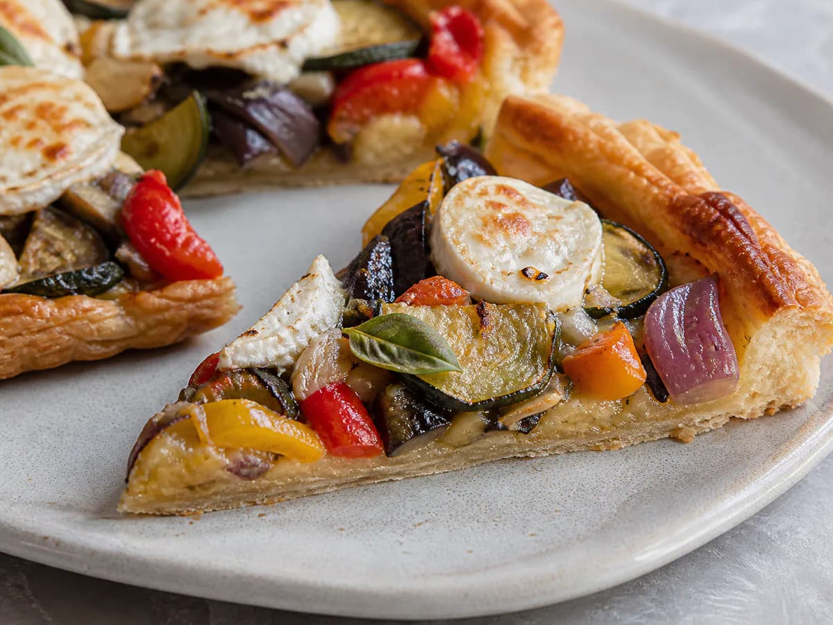 Pormenor de uma porção de Tarte de Legumes Assados e Queijo de Cabra